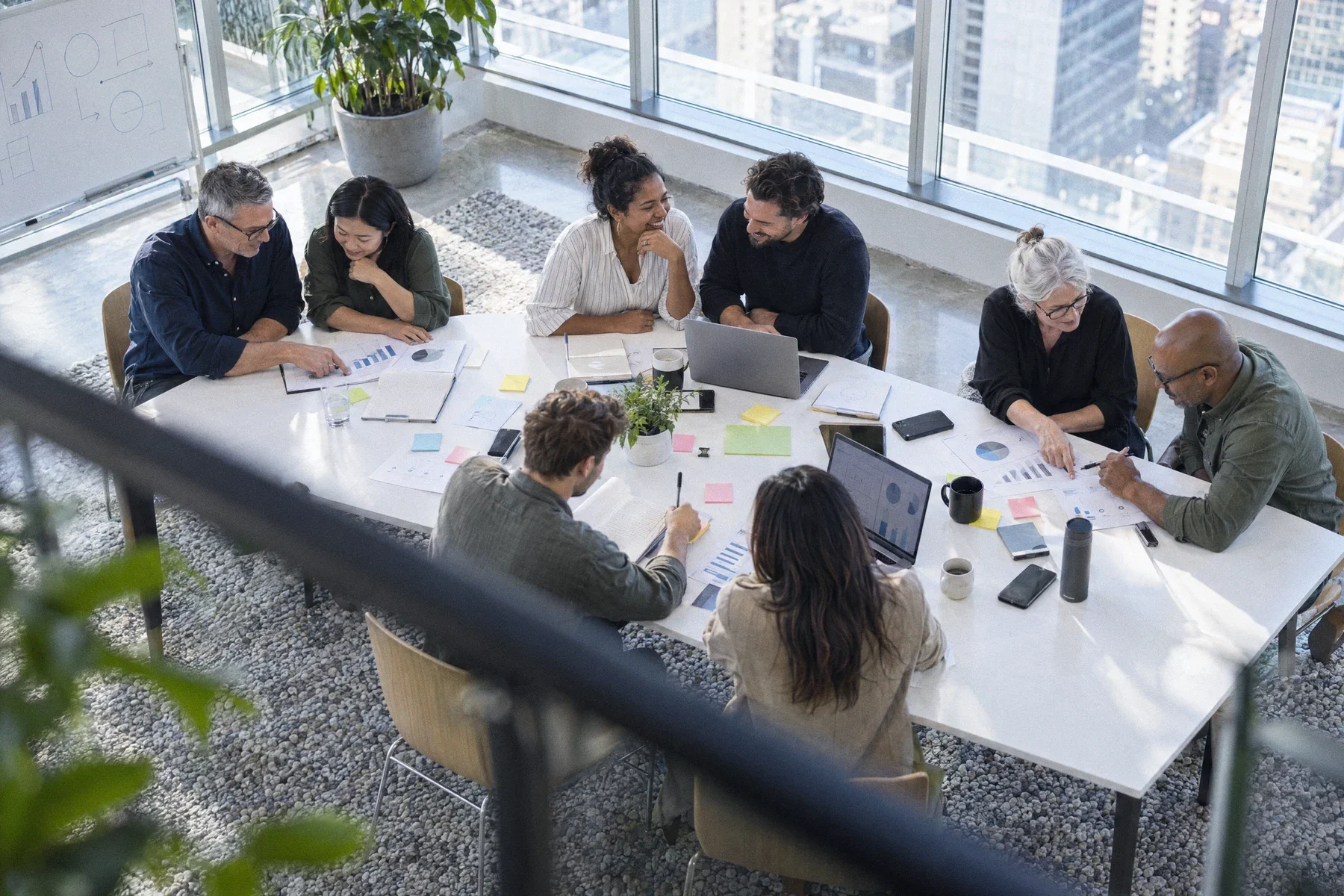 A team working in small groups around a long table, seen from above
